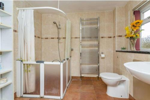 y baño con ducha, aseo y lavamanos. en Spacious 5 Bedroom 11 Guest Family House in Horsham en Roffey