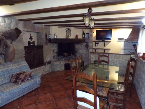 a living room with a glass table and a fireplace at Apartamentos Jose Andres in Viana