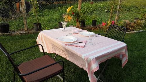 a table with a pink and white table cloth and two chairs at Lar do solpor in Allariz