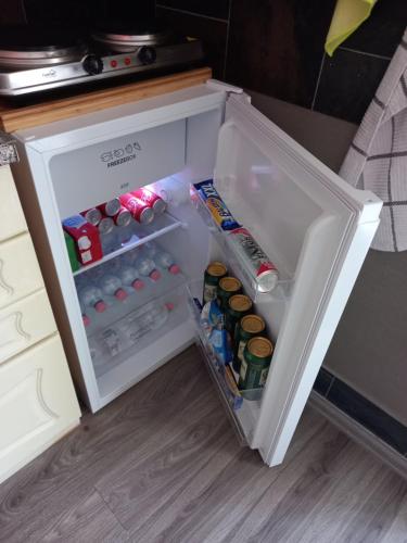 an open refrigerator filled with drinks and sodas at Kiskassa Vendégház 