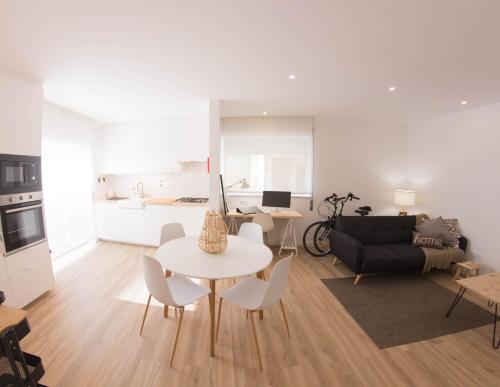 a living room with a table and chairs and a couch at Apartamento Praia Buarcos in Figueira da Foz