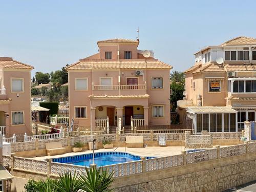 a house with a swimming pool in front of it at Olive Tree Bungalow La Zenia in Orihuela Costa