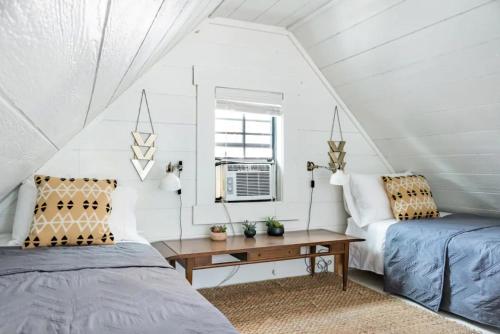 a bedroom with two beds and a table at Hip, Cozy Cottage with a Fire Pit in Cleveland Park in Nashville