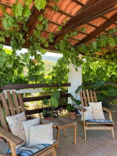 a patio with two chairs under a pergola at Studio apartment with swimming pool in Jelsa