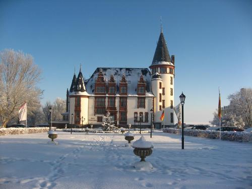 a large building with snow on the ground at Seehotel Schloss Klink in Klink