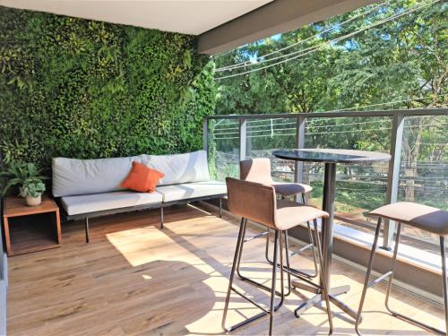 un patio con un banco y una pared verde en Studio em Pinheiros SP, en São Paulo