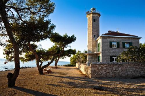 un phare au-dessus d'un bâtiment à côté de l'eau dans l'établissement Apartments Iris, à Vir