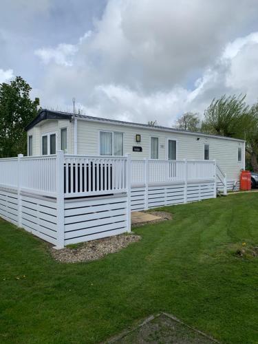 a white fence in front of a house at Meadows 3 NEW BEACH HOLIDAY PARK in Dymchurch