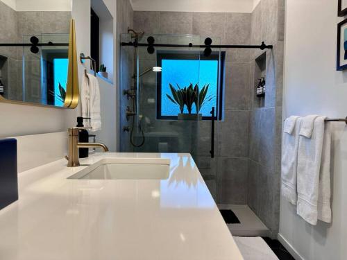 een witte badkamer met een wastafel en een douche bij Greenwood Getaway in Seattle