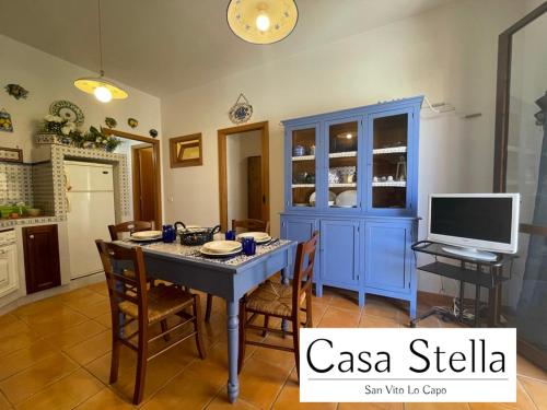 een eetkamer met een blauwe tafel en een tv bij Casa Stella San Vito Lo Capo in San Vito lo Capo