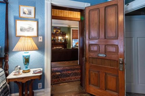 a hallway with a door and a table with a lamp at The Dolon House Bed & Breakfast! in Jim Thorpe