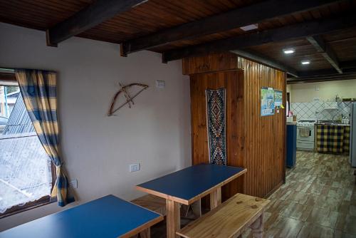 Habitación con mesa azul y cocina en Holger sofus en Ushuaia