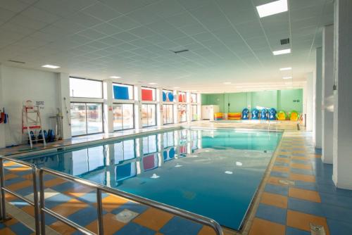 ein Pool mit blauem Wasser in einem Gebäude in der Unterkunft Vacation Escape - Valley Farm -Clacton-on-sea - Holiday Park in Clacton-on-Sea