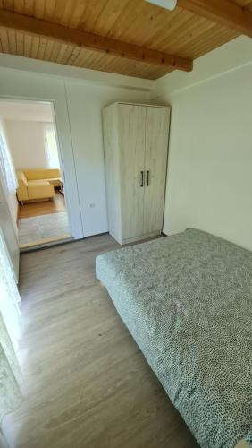 ein Schlafzimmer mit einem Bett, einem Schrank und einer Tür in der Unterkunft Vikendica stan na dan Bujačić, Valjevo in Valjevo