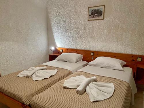 two beds sitting next to each other with towels on them at Lefka in Kolymvari
