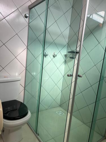 a bathroom with a glass shower with a toilet at Hotel São Vicente in Araguaína