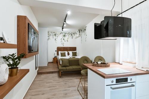 una cucina e un soggiorno con divano e TV di Sabbia Mini Pool Suites a Preveza