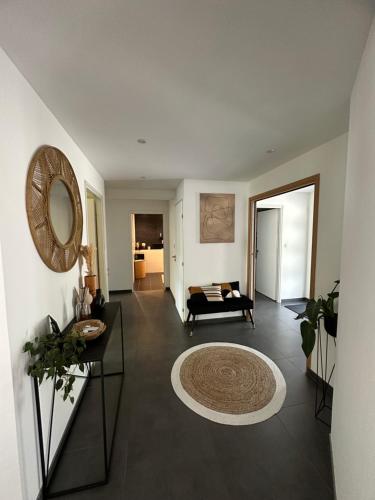 een woonkamer met een bank en een spiegel bij Grand appartement de 119m2 avec jardin de 219m2 in Quimper