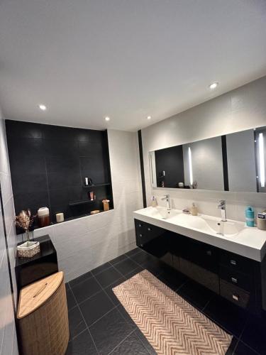een badkamer met 2 wastafels en een grote spiegel bij Grand appartement de 119m2 avec jardin de 219m2 in Quimper