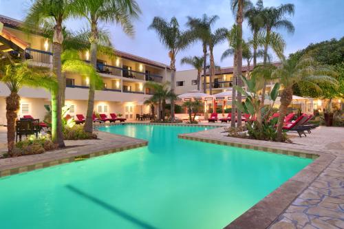 una piscina resort con palmeras y sillas en Atrium Hotel Orange County, en Irvine