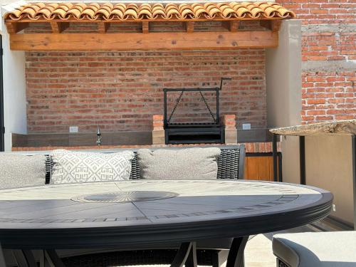 a table in front of a brick wall at Doña Jose Suite & Apartments in San Miguel de Allende