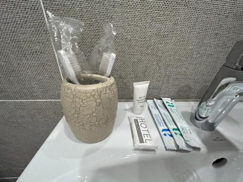 a toothbrush holder on a sink with toothbrushes and toothpaste at Первая береговая линия, набережка in Aktau