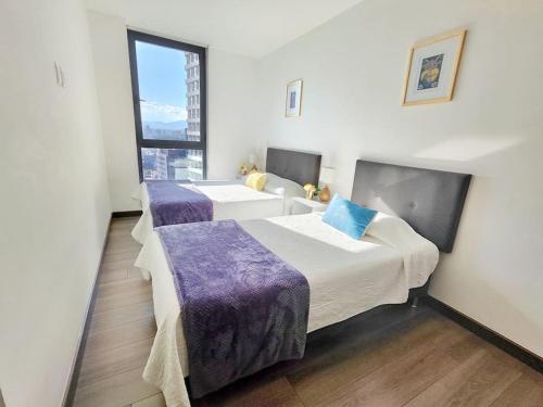 una camera d'albergo con tre letti e una finestra di Emilia MaiaHome-2BD Amazing view in Polanco -Pool Gym SPA a Città del Messico