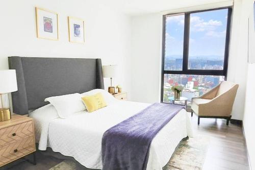 una camera da letto con un letto e una grande finestra di Emilia MaiaHome-2BD Amazing view in Polanco -Pool Gym SPA a Città del Messico