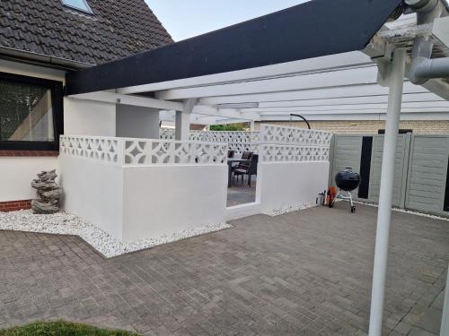 a white pergola with a table on a patio at Harmonie, an der Nordküste in Nordenham