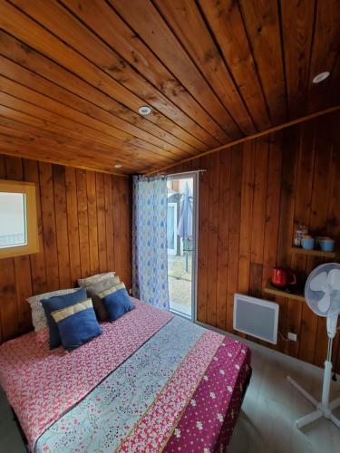 1 dormitorio con 1 cama con techo de madera en Studio - Chalet indépendant, en Décines-Charpieu