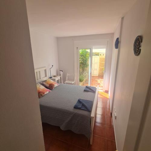 1 dormitorio con 1 cama y puerta que da a un patio en Habitación doble con baño y terraza privada en El Médano