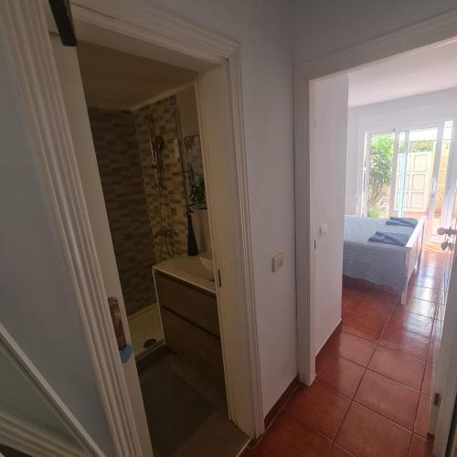 a hallway with a room with a bed and a door at Habitación doble con baño y terraza privada in El Médano