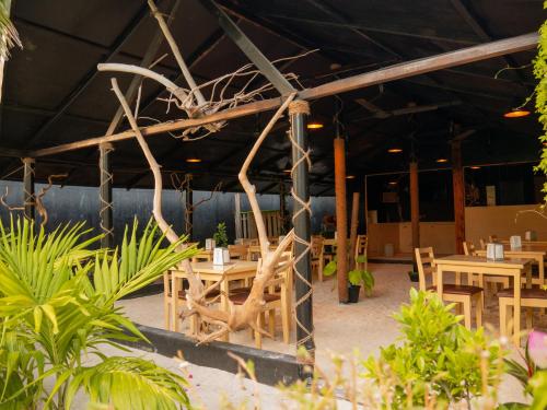 a restaurant with wooden tables and chairs and plants at Turtle Maldives - Your Gateway to the Beach & Marine Adventures Await! in Omadhoo