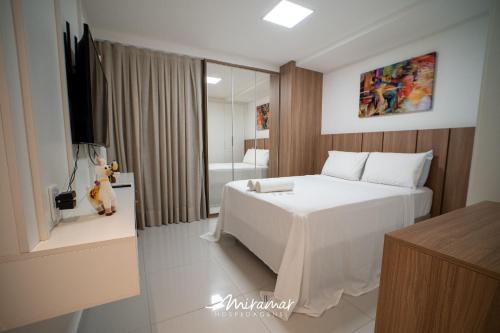 1 dormitorio con 1 cama blanca grande y baño en Lindo apartamento de 2 quartos no Cayenne, en João Pessoa