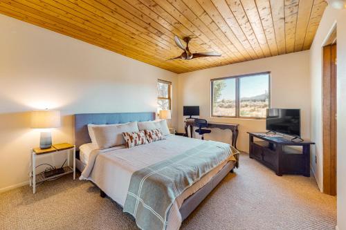 Casa Luna في Ranchos de Taos: غرفة نوم بسرير وتلفزيون بشاشة مسطحة