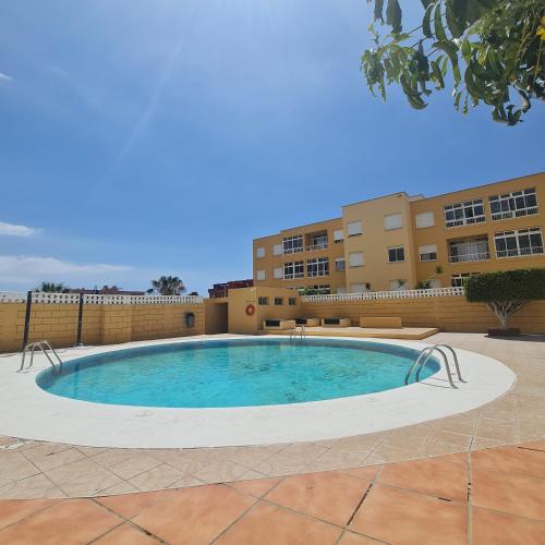 a large swimming pool in the middle of a courtyard at Habitación doble con baño y terraza privada in El Médano