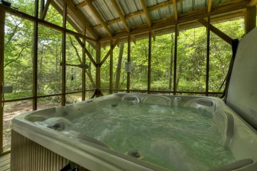 eine Whirlpool-Badewanne in einem Baumhaus in der Unterkunft A River Runs Through It in Cherry Log