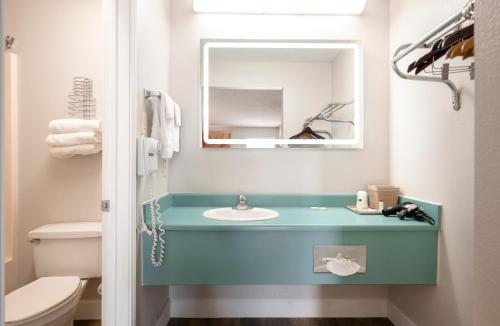 ein Badezimmer mit einem blauen Waschbecken und einem Spiegel in der Unterkunft RIVER OAK INN in Bandera
