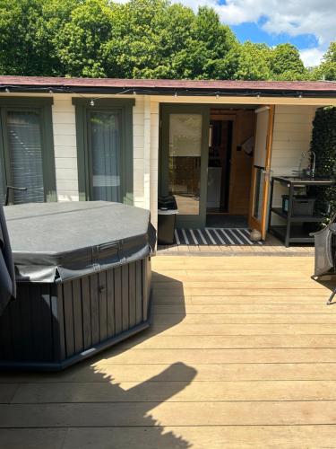 a porch of a house with a covering on it at Beauslodge Authentic Log Cabin With Private Hot Tub in Arford