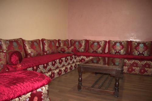 a living room with a red couch and a table at Hagounia hotel in Tan-Tan