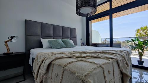 una camera da letto con un grande letto con una grande finestra di SUNSET WAVES relax apartment a Benidorm