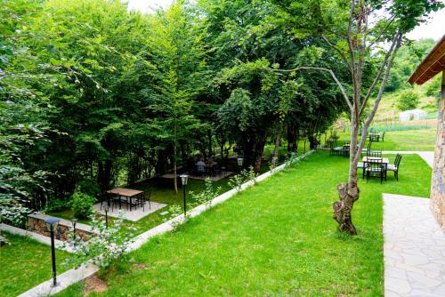 einen Park mit Bänken, Tischen und Bäumen in der Unterkunft HANI CEPIT in Librazhd
