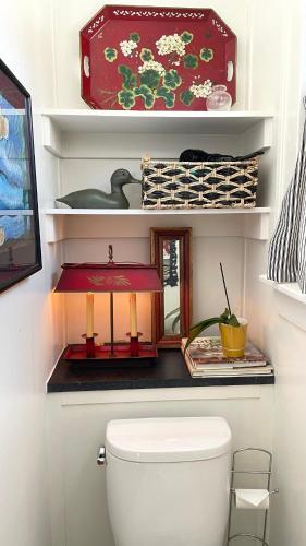 a bathroom with a toilet and a shelf with items at Lake Perch in Lakeside