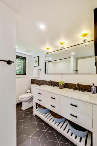a bathroom with a toilet and a large mirror at Springfield Beach House in Union Pier