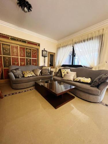 Sala de estar con 2 sofás y mesa de centro en مارينا الساحل الشمالى en ‘Ezbet `Abd el-Ḥamîd