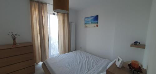 een kleine slaapkamer met een bed en een raam bij Joy Apartments in Mangalia