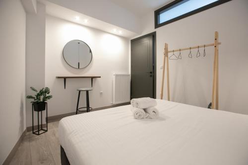 a bedroom with a white bed with a towel on it at Casa de Castro - City Apartments in Thessaloniki