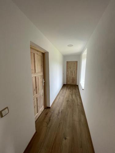 an empty room with wooden floors and doors at Chalupa Sviny in Sviny