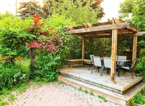 a wooden gazebo with a table and chairs on a patio at Luxury 2 Bedroom House in Richmond Hill