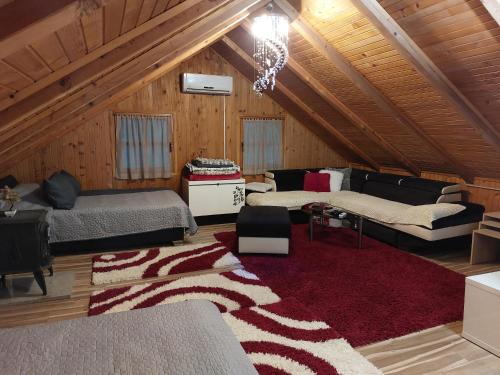 a attic room with two beds and a couch at FortUNA Holiday Home in Bihać